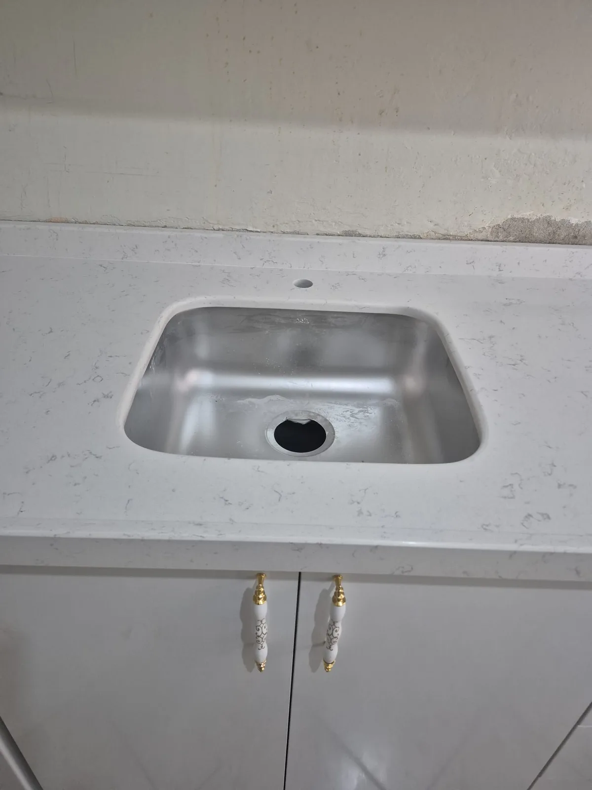 Beyaz mermer tezgah lavabo ve altın batarya montajı